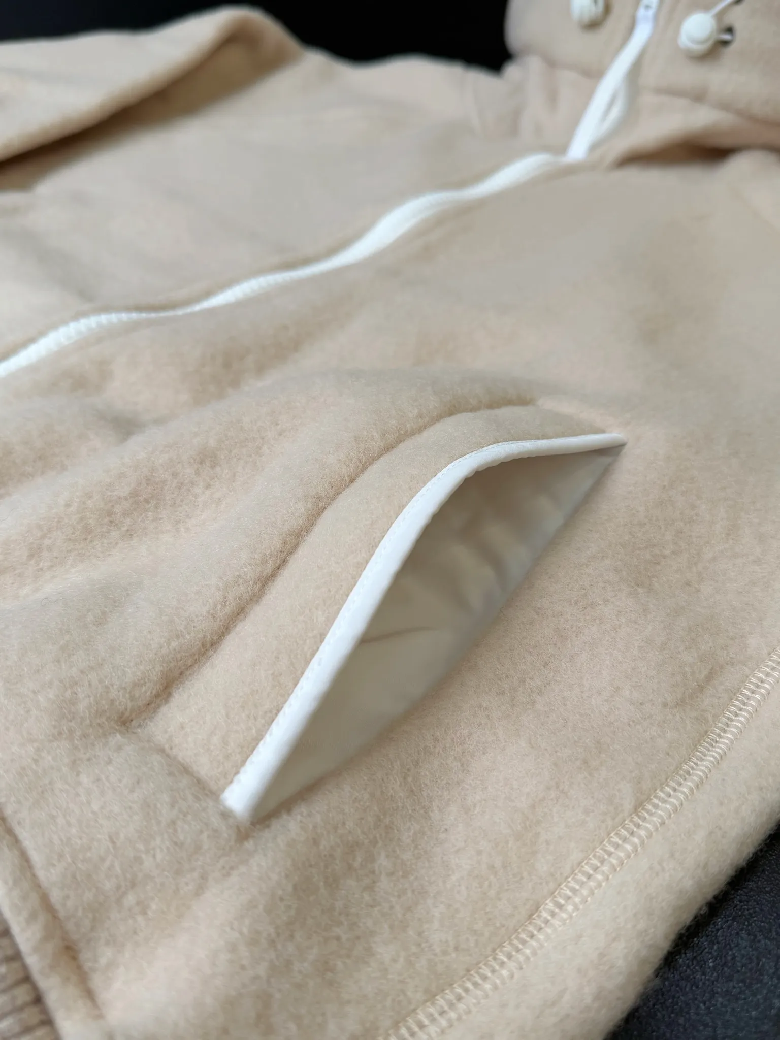 P660 Canada Goose Fleece Wool Badge Hooded Jacket Fabric selection: Wool fleece fabric blended with wool as the main body and a very small amount of spandex and polyester fiber. Wool is a core natural ingredient that provides unparalleled temperature regulation, antibacterial and anti-odor properties and a skin-friendly feel. The feeding of a small amount of spandex gives the fabric a certain degree of four-way elasticity, making it non-restrictive during daily activities. As the basis of fleece's structure, polyester fiber enhances the fabric's durability, wrinkle resistance and quick-drying properties. It contributes to the loft of the fleece and provides functions such as trapping air.  Detail 1: The sleeves and hem are closed with 2×2 ribbing. Its strong elasticity can closely fit wrists and waists of different thicknesses, forming an effective 'seal' to prevent cold wind from blowing back. It can still maintain its original shape after repeated stretching and use, and is not easy to loose and deform. And the ribbed cuffs can convey a sense of design and enhance the visual beauty.  Detail 2: The combination of hood design and elastic buckle improves warmth and windproof performance when wearing. Accessories: Customized elastic drawstring, elastic buckle, custom zipper pendant, custom armband Size: S M L Color: black gray coffee rice pink